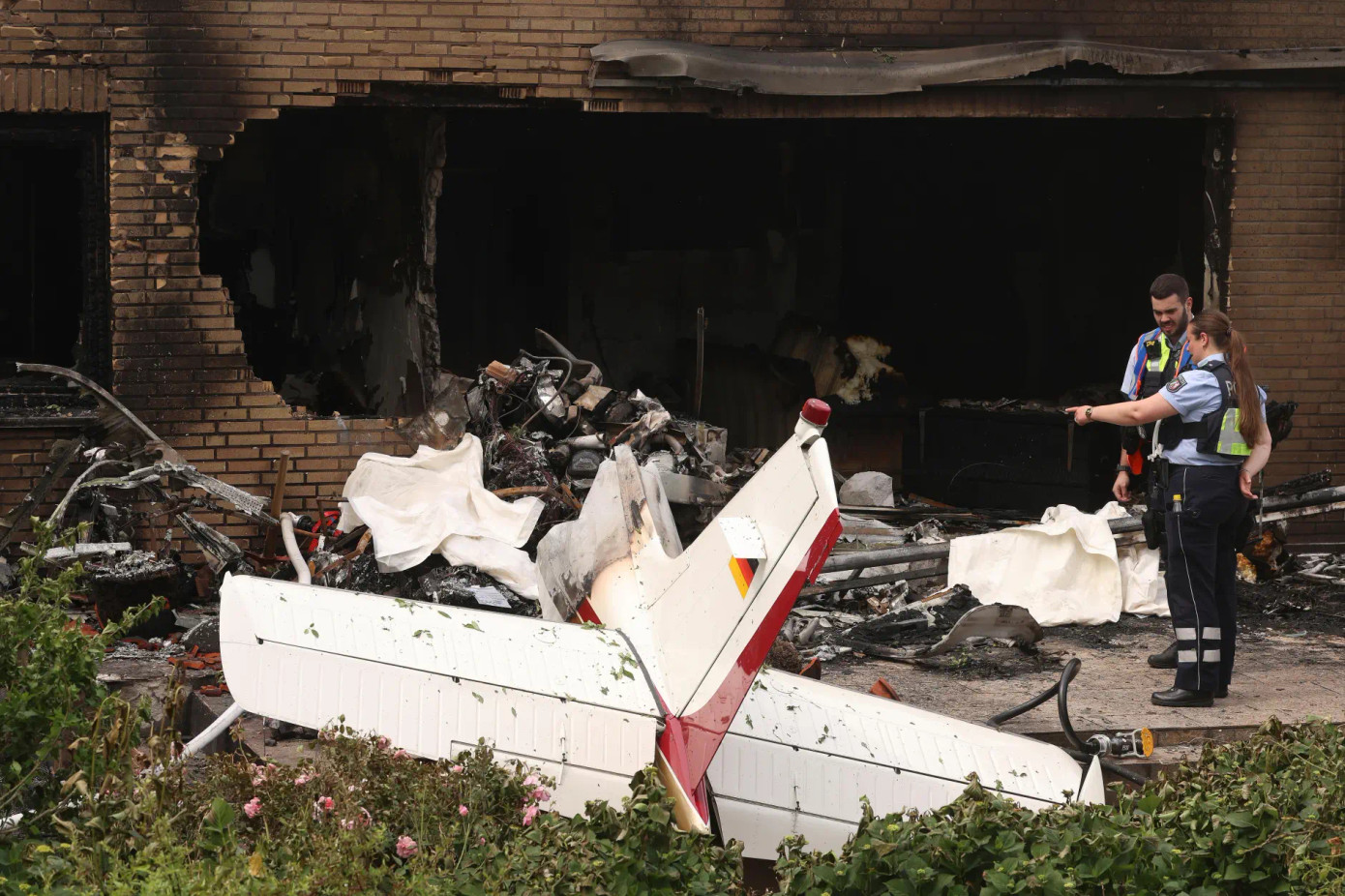 Cảnh sát đang xem xét phần còn lại của một chiếc máy bay bị rơi. Ảnh: AP.