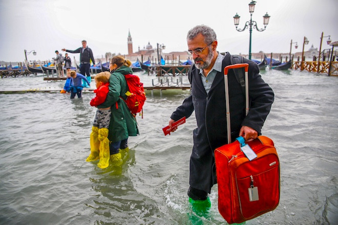 Du khách di chuyển khi gặp bão ở Venice, Ý. Ảnh: Gismeteo.