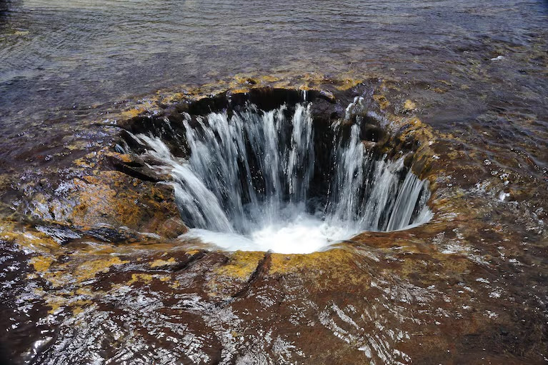 Nước chảy vào miệng hố, nhưng chưa ai xác định được nước sẽ đi đâu. Ảnh: Terry McDermott. Nước chảy vào miệng hố, nhưng chưa ai xác định được nước sẽ đi đâu. Ảnh: Terry McDermott.