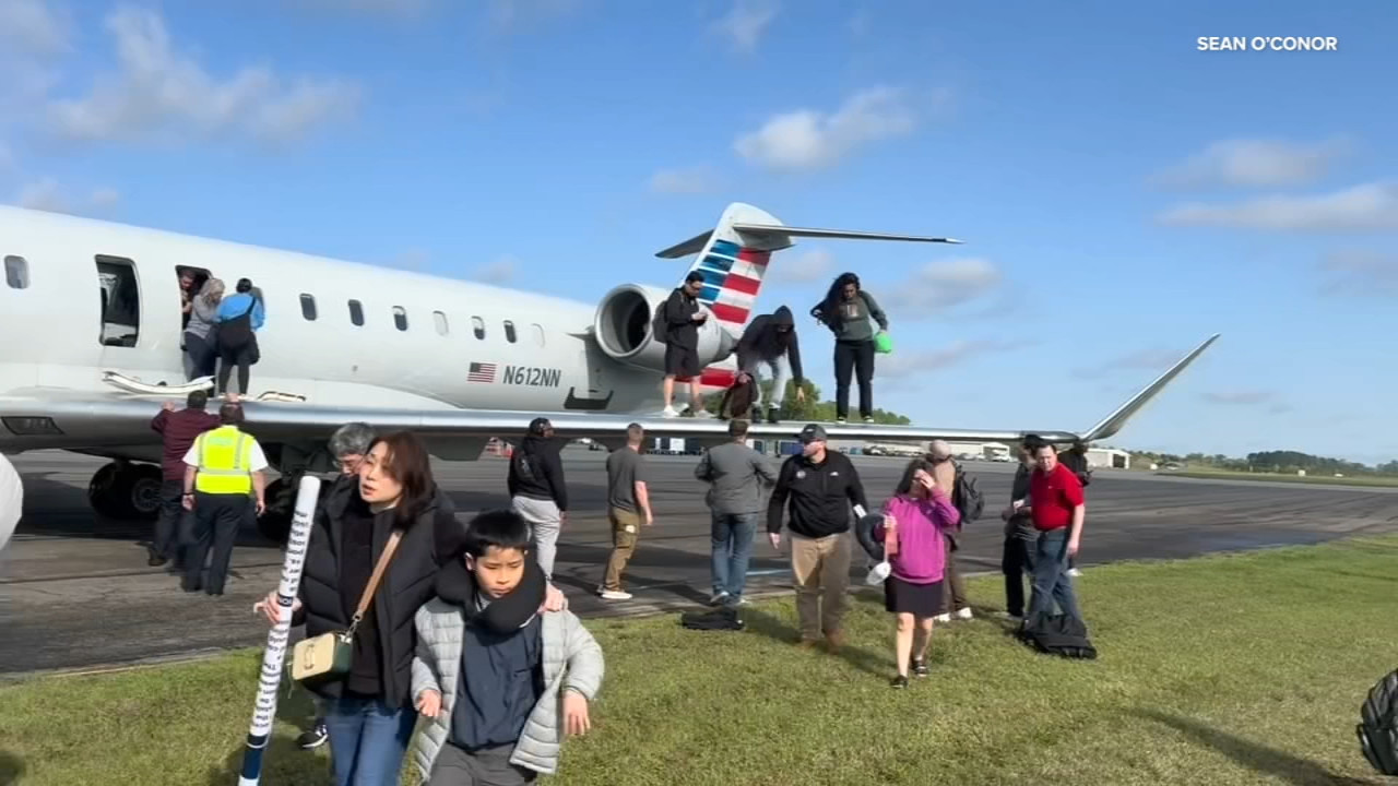 Hành khách thoát khỏi máy bay xuống cánh và nhảy khỏi chuyến bay 5406 của American Eagle. Ảnh: Sean O'Conor.