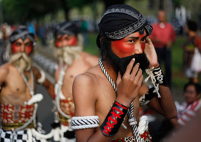 Một vũ công truyền thống đeo râu giả để chuẩn bị biểu diễn trong lễ diễu hành ở Jakarta, Indonesia