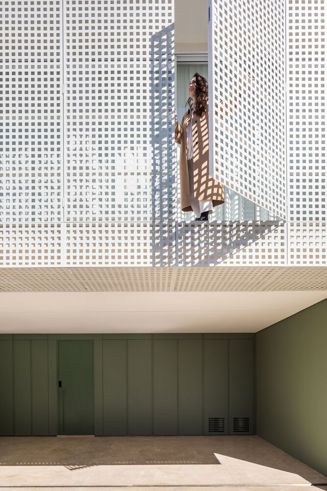 Mặt tiền tầng trệt được sơn màu xanh lá cây, tương phản với màu trắng của toàn bộ ngôi nhà.