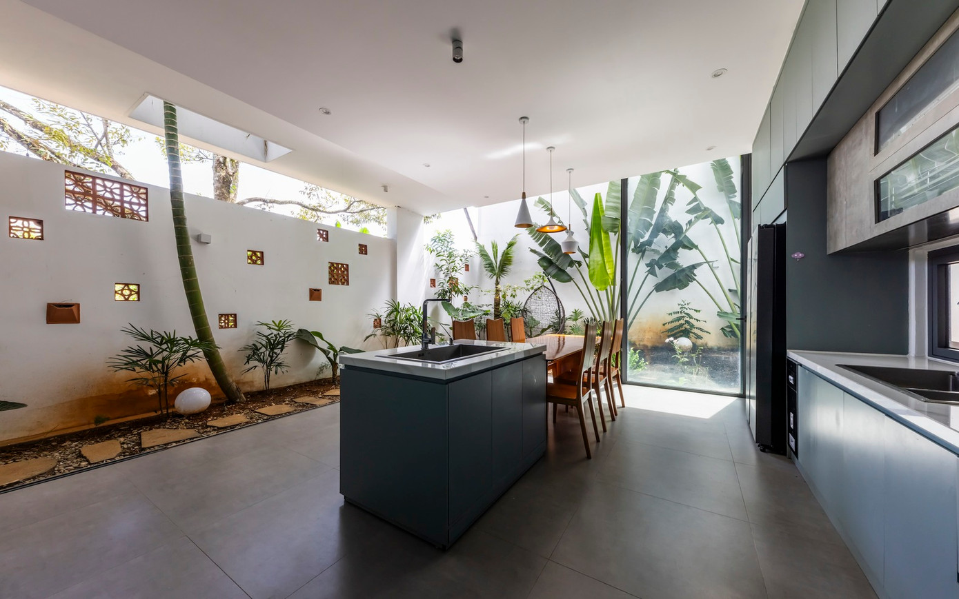 Nhà bếp hiện đại có một hòn đảo lớn và đồ nội thất tiện dụng được sắp xếp gọn gàng. Các tông màu trung tính và màu xanh lam nhẹ nhàng của tủ bếp tạo nên bầu không khí hài hòa, mang đến cảm giác nhẹ nhàng nhưng hiện đại.