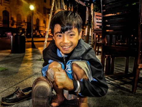 Nụ cười của em – Tác giả người Việt Nguyễn Bông chụp tại Hồ Chí Minh. “Nụ cười trong trẻo của em bé sớm phải bước vào cuộc mưu sinh nhọc nhằn đã đem lại cho tôi một cảm xúc kỳ lạ trong những ngày Tết âm lịch vừa qua. Khi nhà nhà quây quần bên mâm cơm thịnh soạn và ăn vận những áo quần đẹp nhất, em bé này vẫn ngày ngày xách hộp đi đánh giày nhưng nụ cười em vẫn rất tươi vui.”