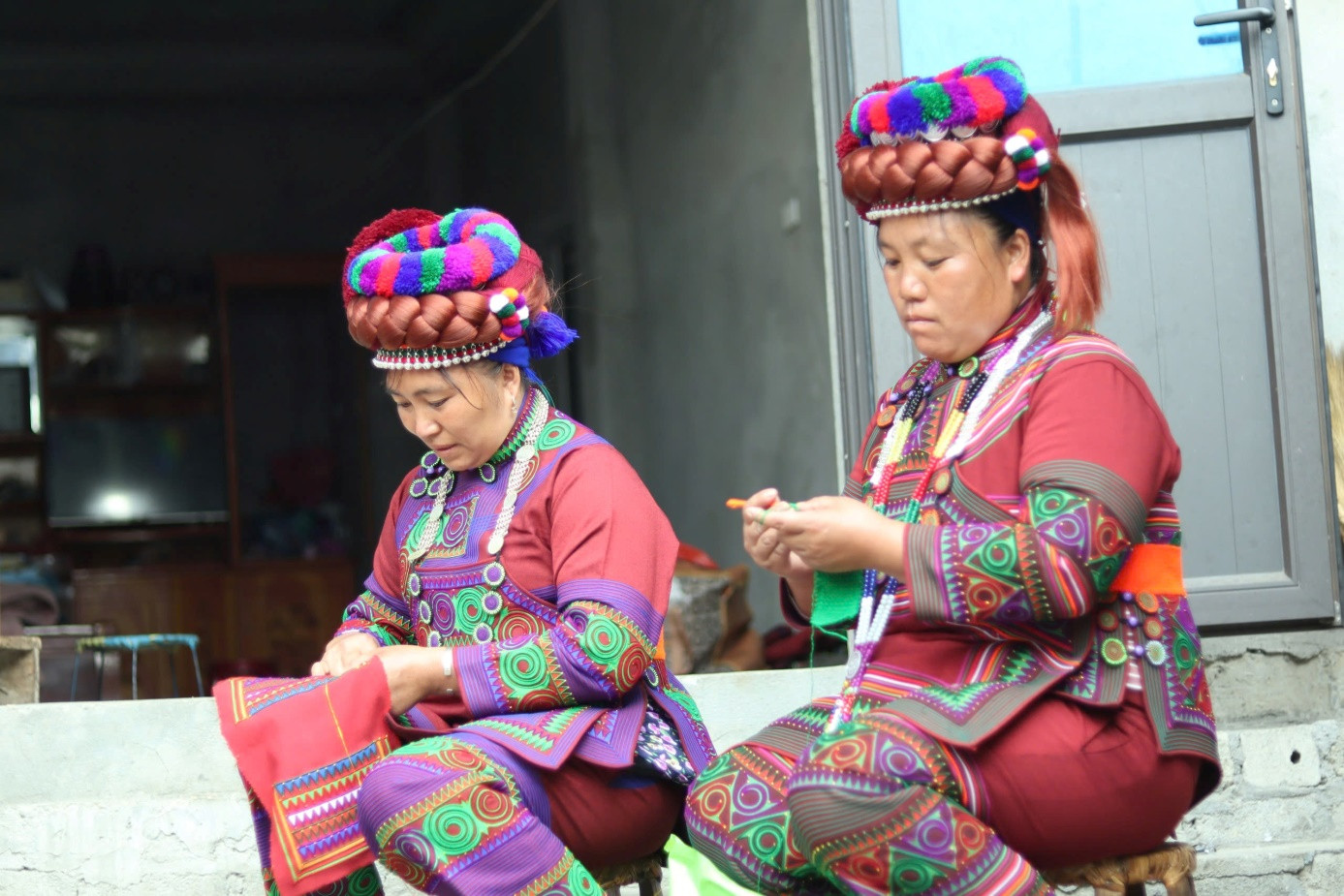 Thời gian rảnh rỗi phụ nữ Hà Nhì đen thêu thùa dưới hiên nhà.