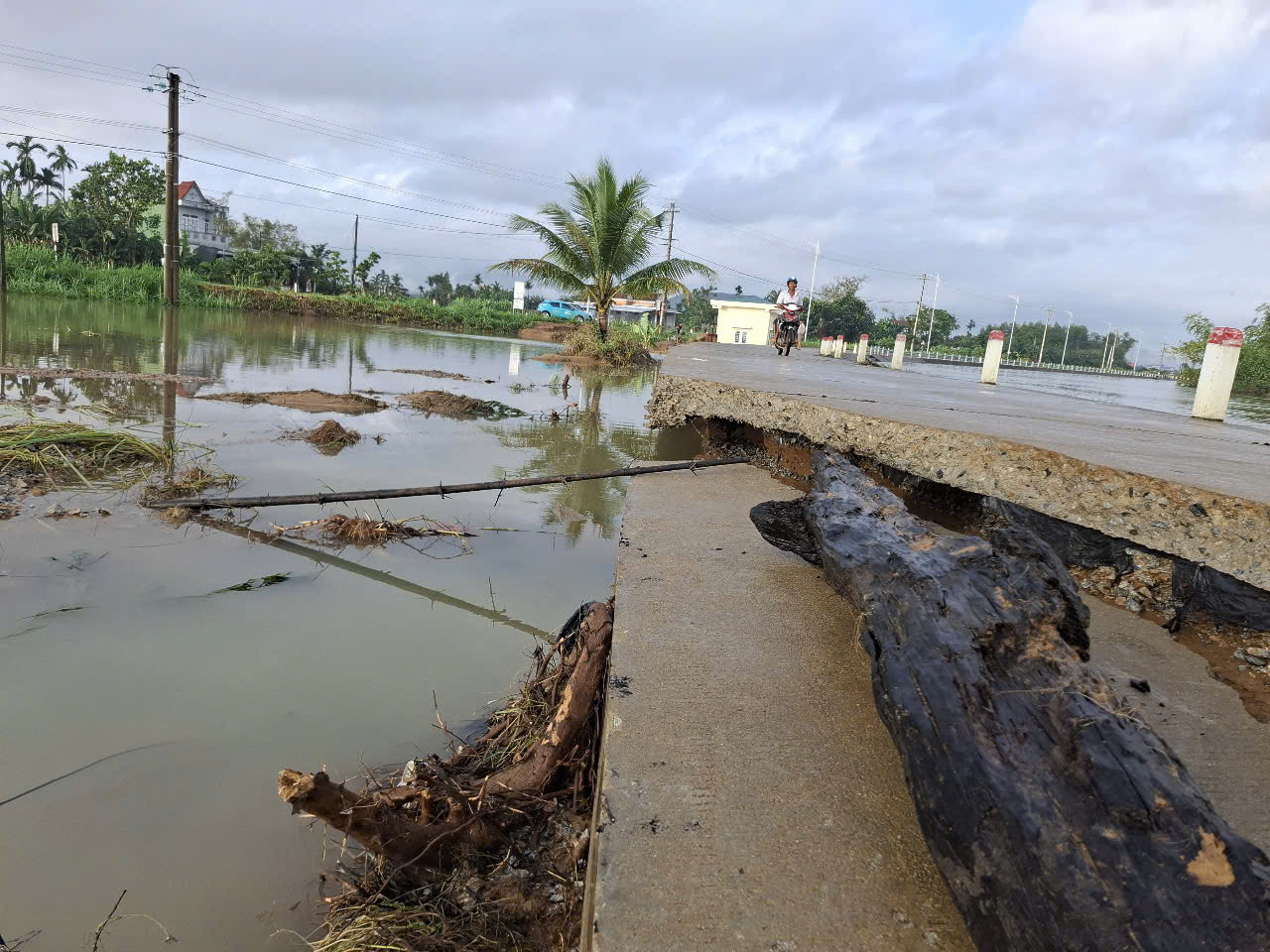 Một đoạn đường ở thị xã Đức Phổ bị gãy nát phần bê tông phần mặt do nước chảy xiết.
