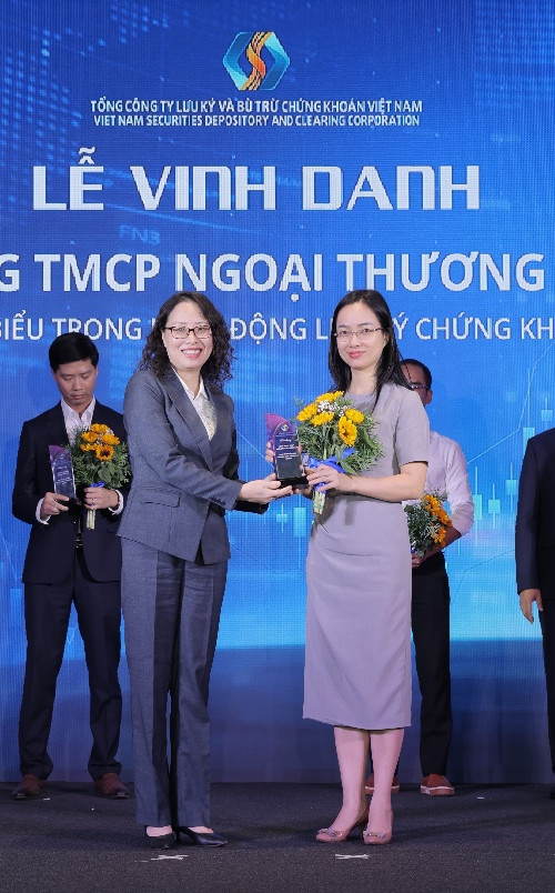 Bà Tạ Thanh Bình – Tổng Giám đốc VSDC trao tặng hoa và kỷ niệm chương cho Ngân hàng Vietcombank – Ngân hàng tiêu biểu trong hoạt động lưu ký chứng khoán năm 2024. Bà Tạ Thanh Bình – Tổng Giám đốc VSDC trao tặng hoa và kỷ niệm chương cho Ngân hàng Vietcombank – Ngân hàng tiêu biểu trong hoạt động lưu ký chứng khoán năm 2024.