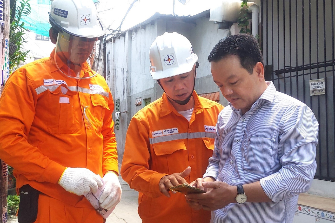 Nhân viên EVNHCMC hướng dẫn khách hàng cài ứng dụng sử dụng dịch vụ điện