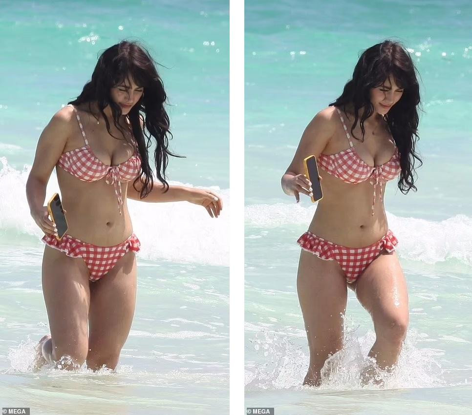 Mái tóc xoăn nhẹ cùng gương mặt trang điểm phong cách tự nhiên giúp người đẹp trở thành tâm điểm trên bãi biển.