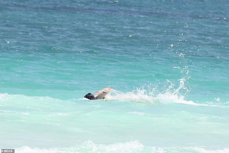 Khác với bạn gái đi biển để "sống ảo", tài tử từng đoạt giải Oscar tận hưởng thời gian bơi lội giữa những con sóng.