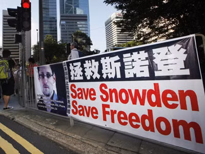 Ngày 25/6, Tổng thống Nga Vladimir Putin cho biết ông Snowden vẫn quanh quẩn ở khu vực quá cảnh của một sân bay ở Mátxcơva (trong ảnh: Người dân Hong Kong căng băng-rôn ghi dòng chữ “Cứu Snowden, cứu tự do”). Ảnh: AP
