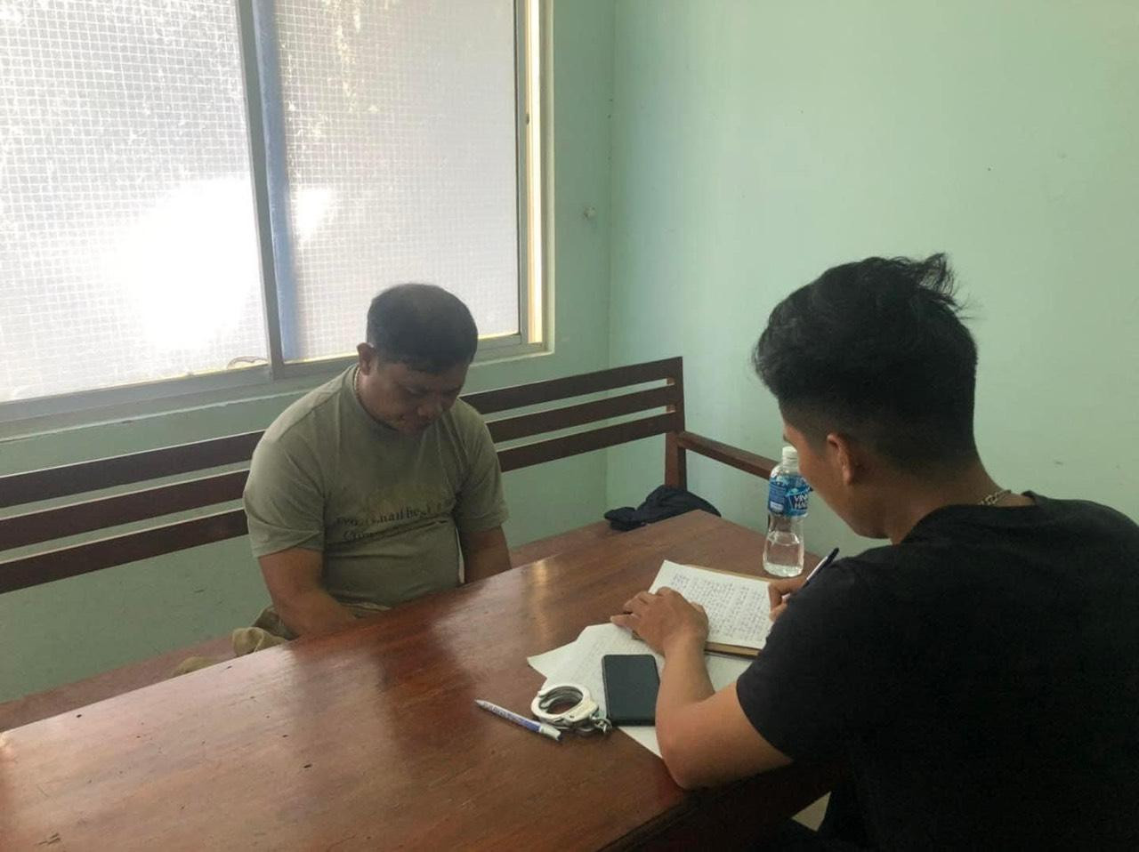 Đối tượng Đặng Văn Vinh (bên trái ảnh) tại cơ quan công an. Ảnh công an cung cấp.