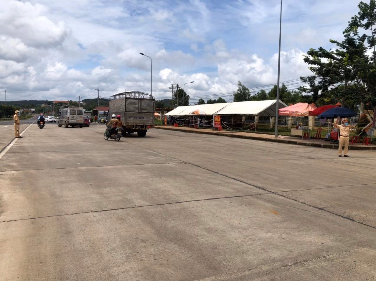 Để tránh việc người dân tụ tập đông tại chốt phòng dịch gia tăng nguy cơ lây nhiễm chéo, Phòng CSGT Đắk Nông đã cử lực lượng và phương tiện dẫn đường cho những người này đến địa phận tỉnh Đắk Lắk. Trong ảnh: Lực lượng CSGT phân luồng xe tại chốt kiểm dịch Cai Chanh