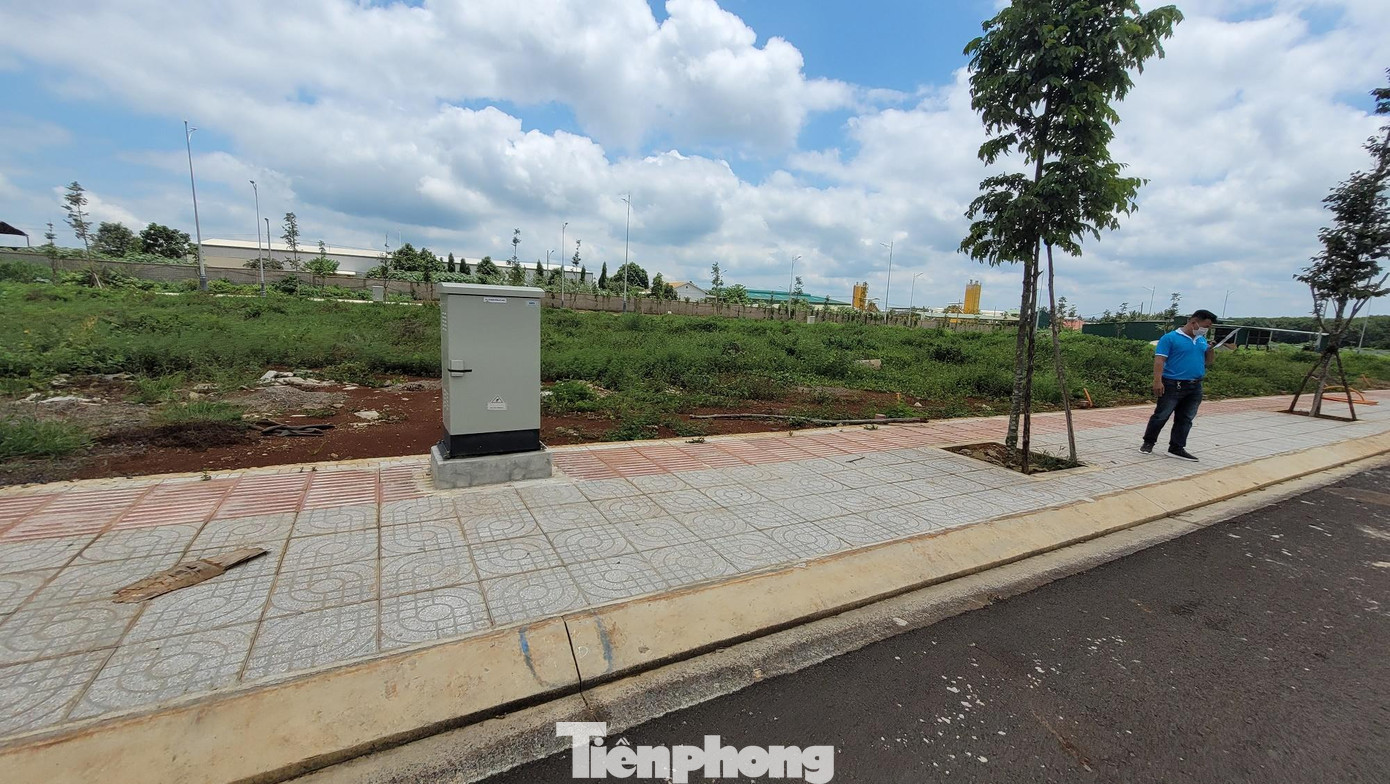 Theo Sở Xây dựng Đắk Lắk, Công ty Ân Phú chưa đủ điều kiện ký hợp đồng bán nhà ở hình thành trong tương lai. Bởi, hồ sơ của doanh nghiệp này mới chỉ có cam kết của doanh nghiệp, chưa được ngân hàng nào đại diện để thực hiện bảo lãnh nghĩa vụ tài chính của chủ đầu tư với khách hàng (trong khi theo quy định phải có-PV). Ngoài ra, chủ đầu tư cũng chưa hoàn thành một số hạng mục cơ bản theo quy định như: trường học, nhà văn hóa. Trong ảnh, nhân viên (áo xanh) của một công ty bất động sản đang giới thiệu bán đất nền tại dự án.