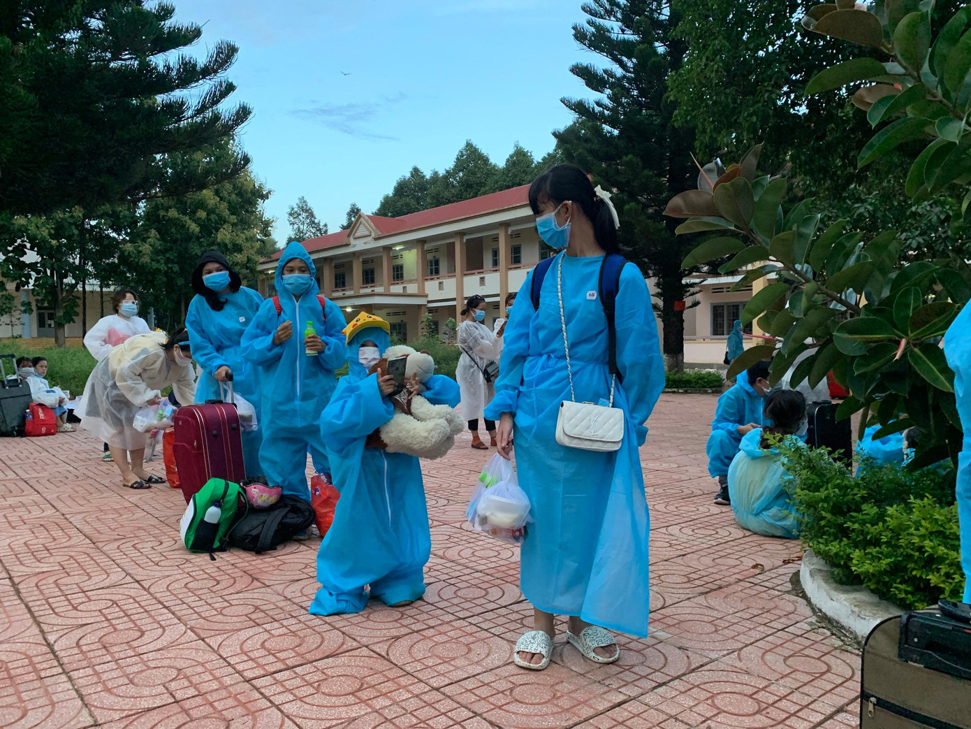 Trẻ em đi theo gia đình được mặc đồ bảo hộ Trẻ em đi theo gia đình được mặc đồ bảo hộ