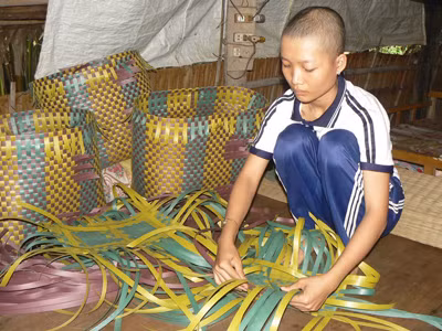 Ái Vân đan giỏ đệm ni lông, một ngày kiếm được 9.000 đồng. Ảnh: Tùng Huyên