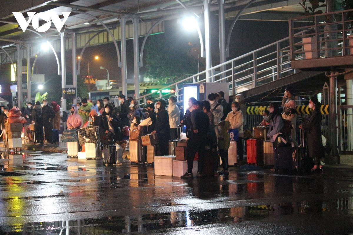 Theo ghi nhận, tại các lối ra của bến xe phía Nam TP. Hà Nội, người dân tập trung đông vừa trú mưa, vừa chờ xe bus, xe taxi đến chở.