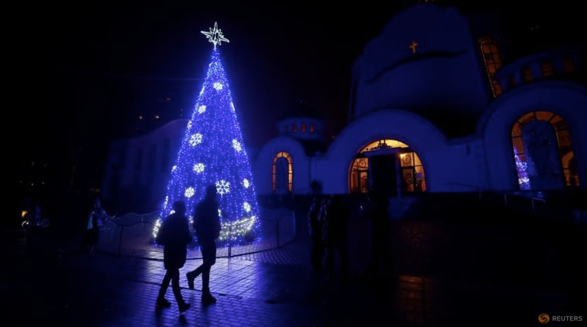 Một cây thông Noel trước nhà thờ Cơ đốc ở Ukraine đêm 24/12. (Ảnh: Reuters)