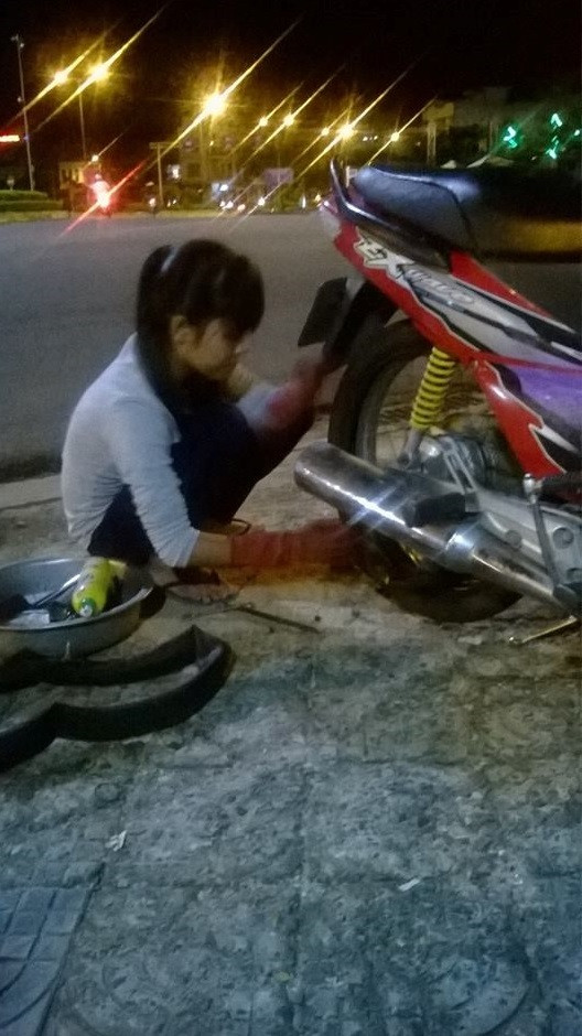 Bức hình thiếu nữ lạc quan vá xe trong đêm được chia sẻ trên các trang mạng xã hội