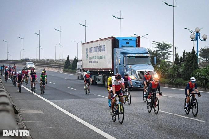 Dòng người đạp xe thể dục "chạy đua với tử thần" khi bên cạnh là xe container đang lưu thông với tốc độ cao. (Ảnh: Mạnh Quân).