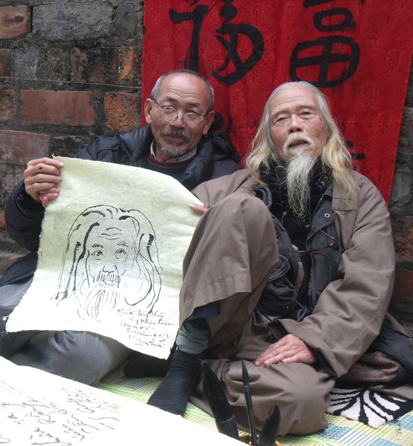 Một người tham quan chụp ảnh cùng với thư pháp gia Cung Khắc Lược - người quen thuộc với phố ông Đồ mỗi khi Tết đến, xuân về