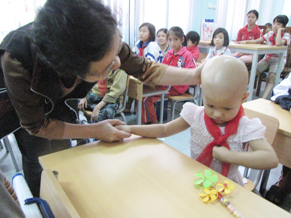 Cô giáo Ngô Anh Thơ, dạy tiếng Anh trong buổi khai giảng của lớp học Hy vọng đang hỏi thăm những sinh viên đặc biệt của mình