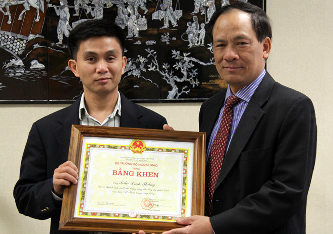 Trần Thắng (trái) nhận bằng khen của bộ trưởng Bộ Ngoại giao do đại sứ VN tại Hoa Kỳ Lê Lương Minh trao tặng vì những đóng góp của anh trong hoạt động duy trì và phát triển văn hóa trong cộng đồng