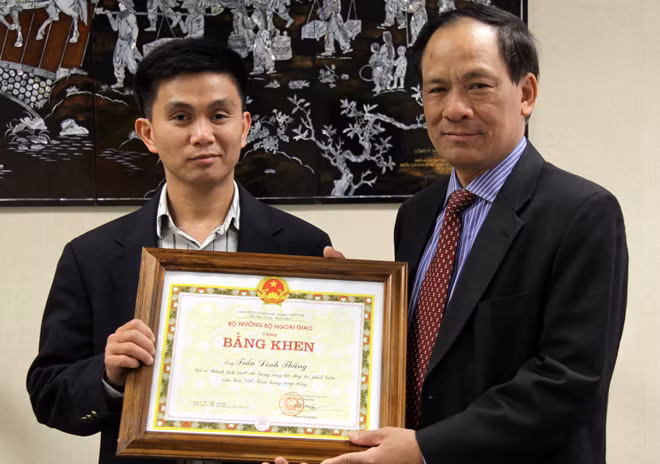 Trần Thắng (trái) nhận bằng khen của bộ trưởng Bộ Ngoại giao do đại sứ VN tại Hoa Kỳ Lê Lương Minh trao tặng vì những đóng góp của anh trong hoạt động duy trì và phát triển văn hóa trong cộng đồng