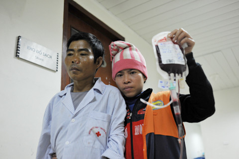 Bên hành lang của Viện Huyết học & Truyền máu T.Ư, chị Nguyễn Thị Nguyên (32 tuổi) dìu chồng là Lương Đức Thảo (47 tuổi) về phòng.