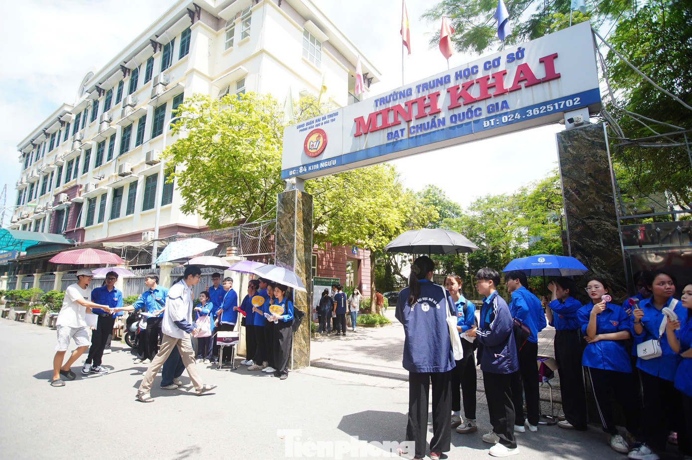 Theo ghi nhận của PV, tại điểm thi Trường Trung học cơ sở Minh Khai (quận Hai Bà Trưng, Hà Nội), đội sinh viên tình nguyện của ĐH Mở Hà Nội đã có mặt trước 1 tiếng so với giờ vào làm thủ tục của thí sinh. Hình ảnh quen thuộc nhưng chưa bao giờ cũ - những bạn trẻ trong màu áo xanh tình nguyện với chiếc mũ tai bèo, nước suối, khăn lạnh, nụ cười thân thiện vẫn âm thầm tiếp lửa cho từng thí sinh dưới nắng gắt.