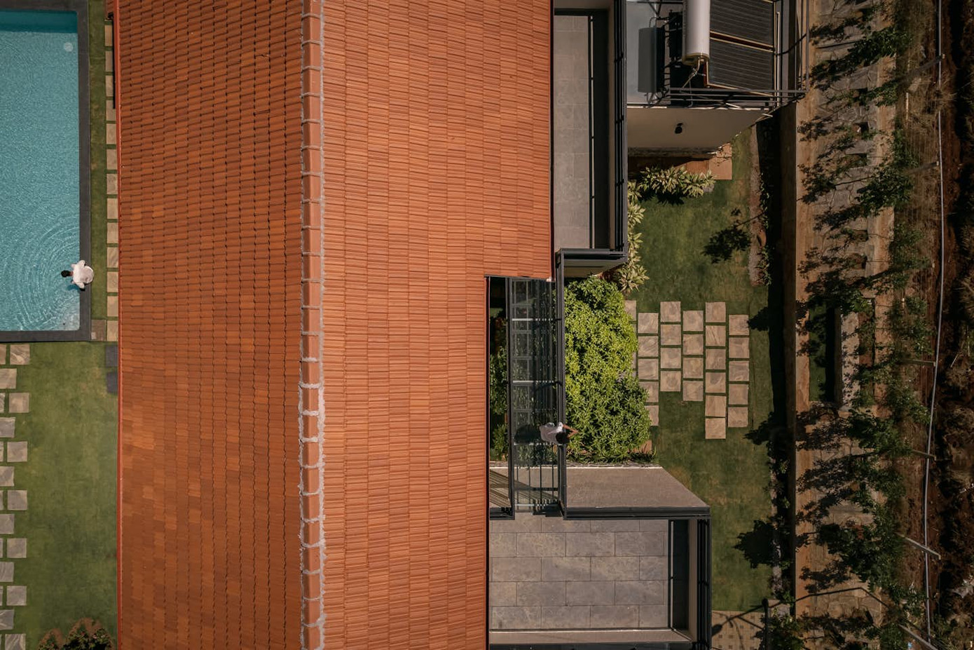 Hình ảnh ngôi nhà được chụp bao quát cầu kính và hồ bơi.