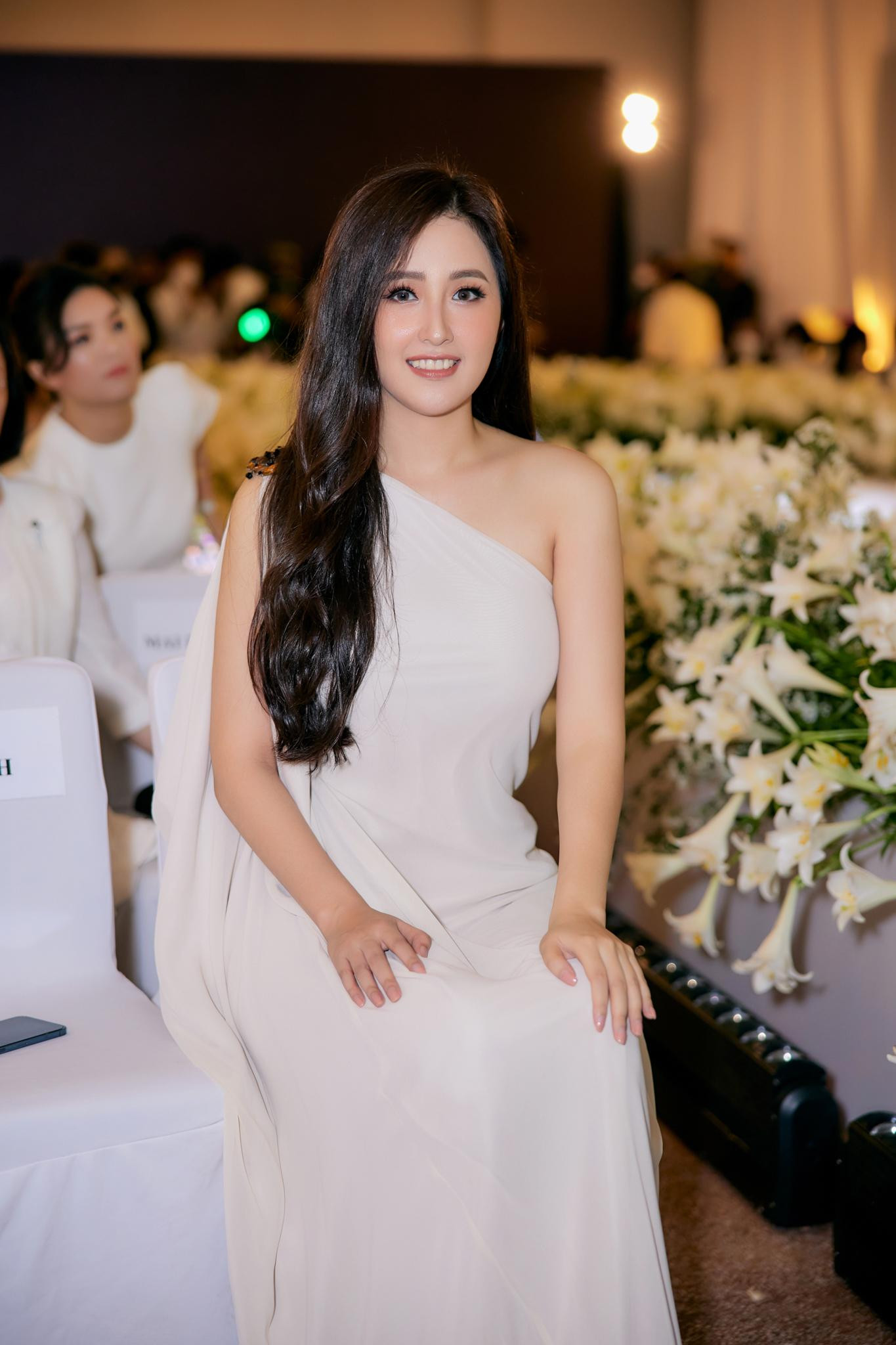 Người đẹp để tóc uốn xoăn, trang điểm nhẹ nhàng và không sử dụng phụ kiện.