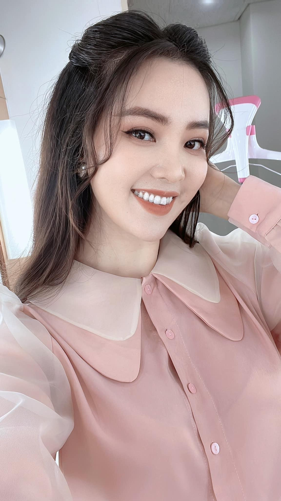 Á hậu Thuỵ Vân xinh đẹp và trẻ trung với áo sơ-mi tông màu hồng pastel.