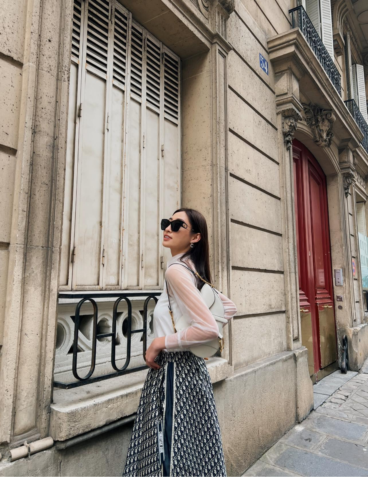 Diện áo sơ-mi trắng xuyên thấu phối cùng chân váy hoạ tiết có kiểu dáng chữ A đã mang lại vẻ cổ điển, hoài niệm cho Lương Thuỳ Linh.