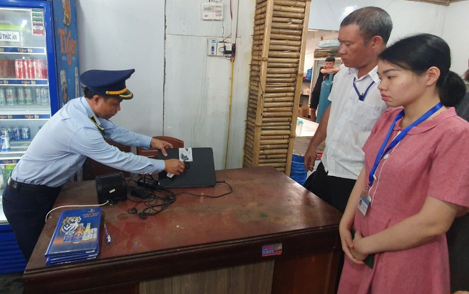 Đoàn liên ngành xé niêm phong máy in hóa đơn để xác minh giá bán của nhà hàng. Ảnh: H.H