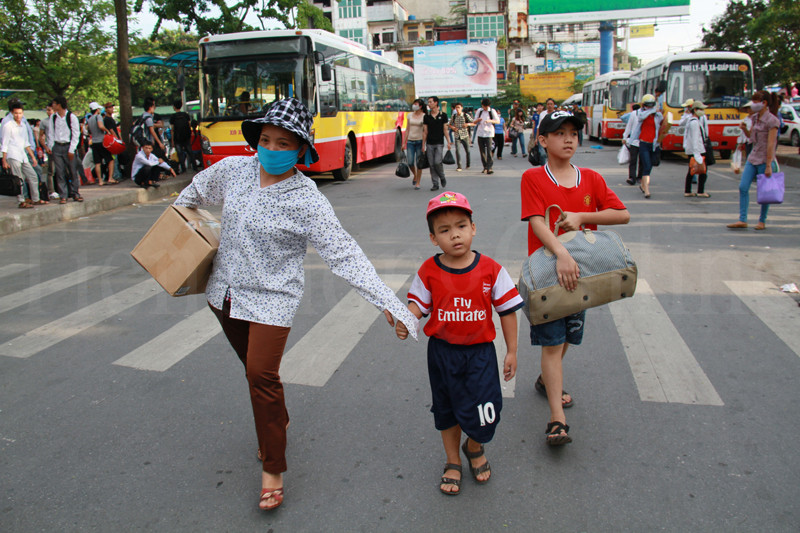 Ba mẹ con vội vã đuổi theo chiếc xe buýt vừa lăn bánh. Ảnh: Trường Phong