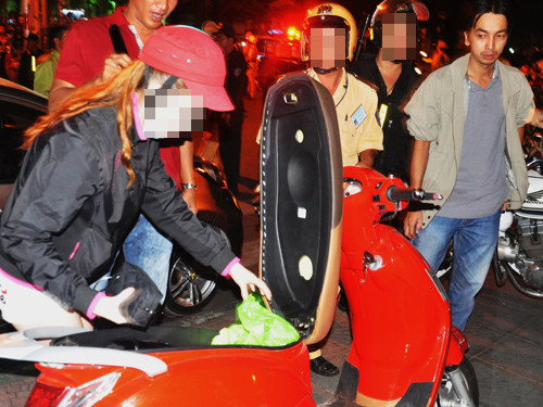 Một thiếu nữ đang mở cốp tìm giấy tờ xe