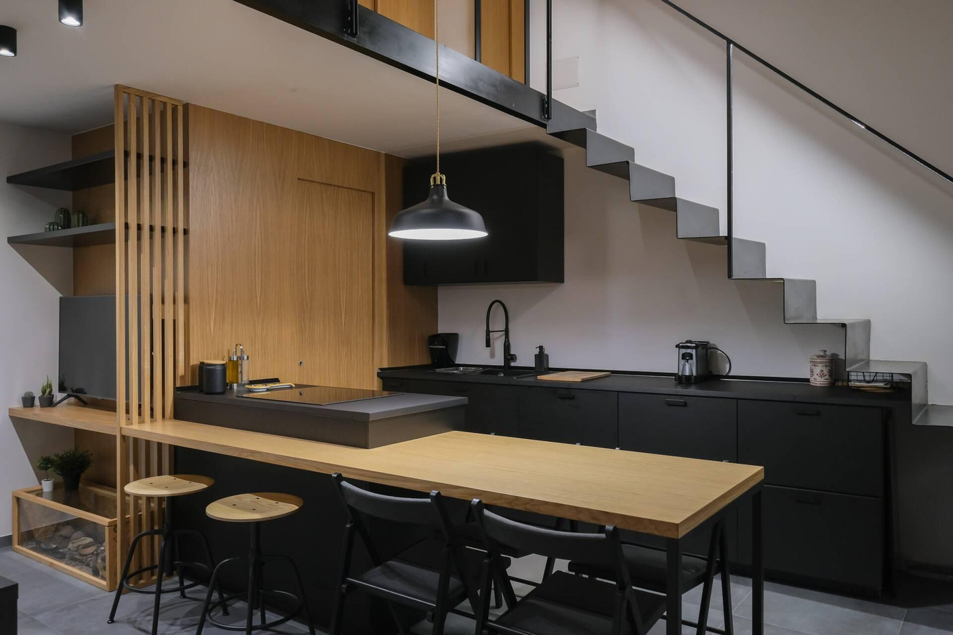 Tầng trệt của công trình dành cho phòng khách và phòng bếp. KTS bố trí khu vực nấu ăn dưới gầm cầu thang.