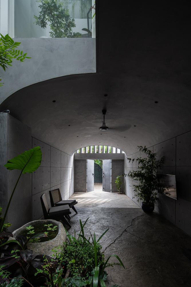 Tại tầng 1, KTS sử dụng chất liệu bê tông thô để xây dựng lối vào, tạo cảm giác như đang bước vào 1 hang động kì bí. Tại lối vào có diện tích để làm gara để xe, tiếp đó là khu vườn với hồ nước và cây cối.