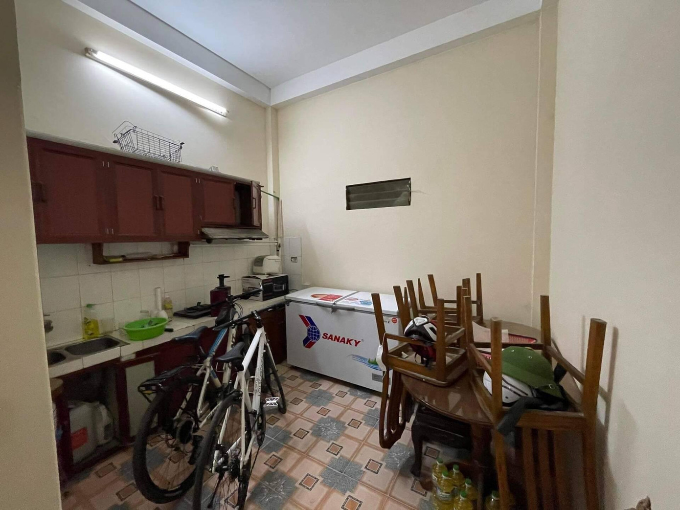 Phần bếp được lược bỏ phần sàn, tường được sơn trắng, hệ thống tủ bếp cũ được thay thế bằng tủ bếp hiện đại, tiện nghi.