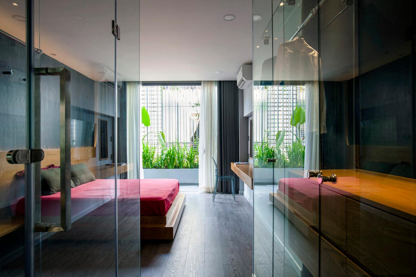 Phòng ngủ chính và phòng tắm được di dời khỏi khu vực phía trước của tầng hai và được hoàn thiện bằng kính lớn, sàn gỗ nhiều lớp và gạch đen.