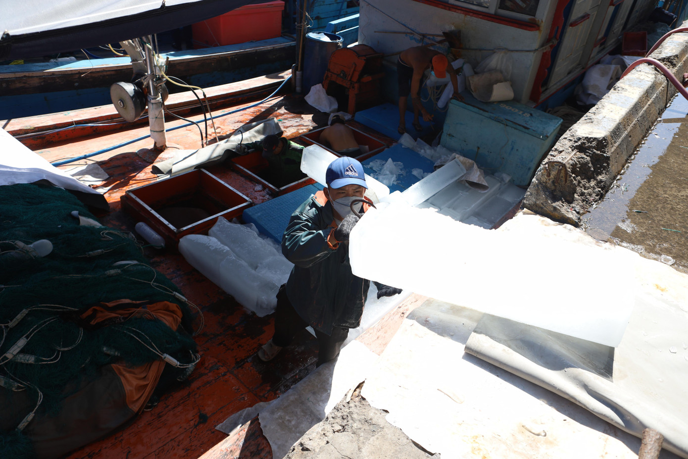 Ngư dân chuyển những cây đá lạnh xuống tàu cho chuyến biển. Ngư dân chuyển những cây đá lạnh xuống tàu cho chuyến biển.