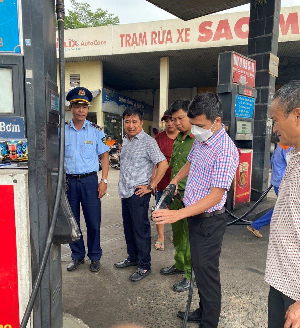 Lực lượng chức năng lấy mẫu kiểm tra nhanh chất lượng xăng tại cây xăng của Công ty Cổ phần Sao Mai Sài Gòn.