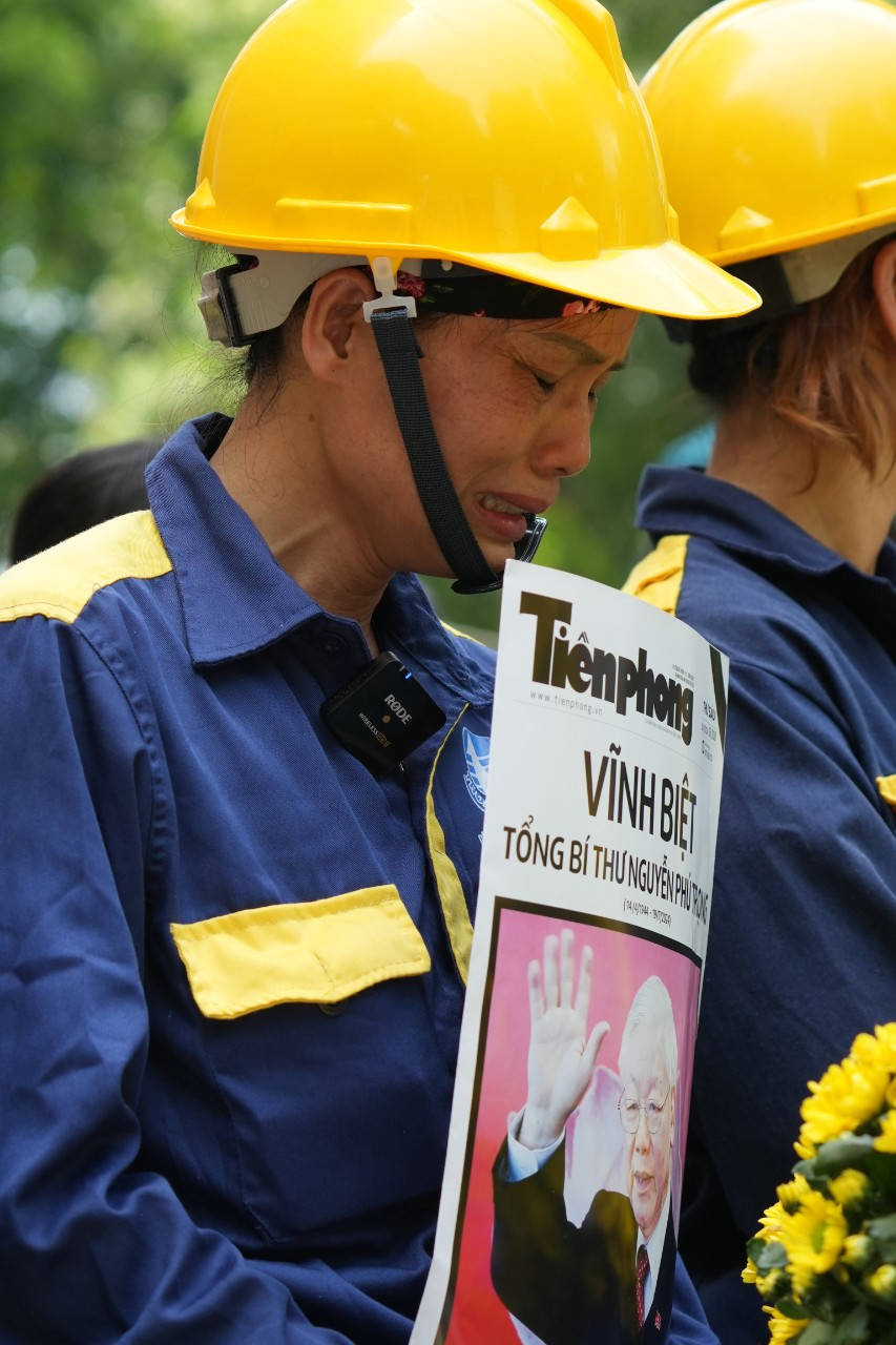 Chị Nguyễn Thị Sen - công tác tại Xí nghiệp thoát nước số 3, trực thuộc công ty Thoát nước Hà Nội không cầm được nước mắt. Ảnh: Mạnh Thắng.