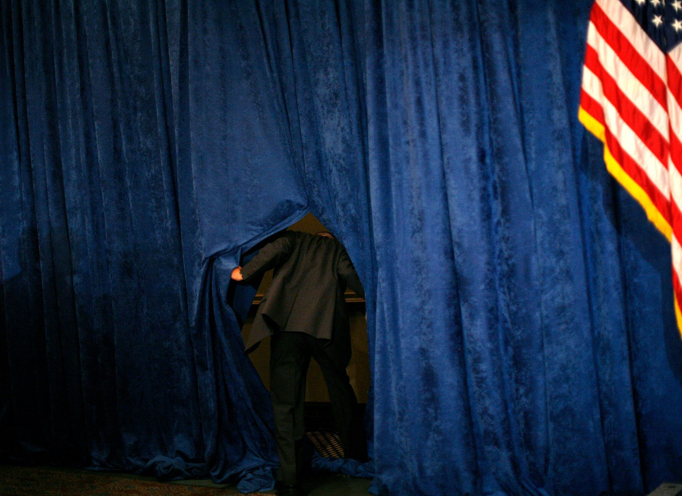 Một đặc vụ kiểm tra phía sau bức rèm trước bài phát biểu của ứng viên tổng thống John McCain tại cuộc họp ở Miami (Florida) ngày 20/5/2008. (Ảnh: Reuters)