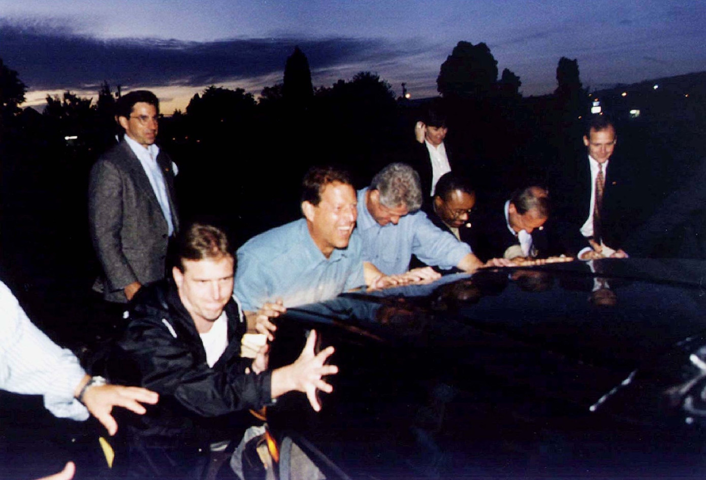 Tổng thống Bill Clinton và Phó Tổng thống Al Gore giúp các đặc vụ đẩy một chiếc Chevrolet Suburban sau khi nó bị mắc kẹt trong bùn ở Woodland ngày 19/9/1996. (Ảnh: Reuters)