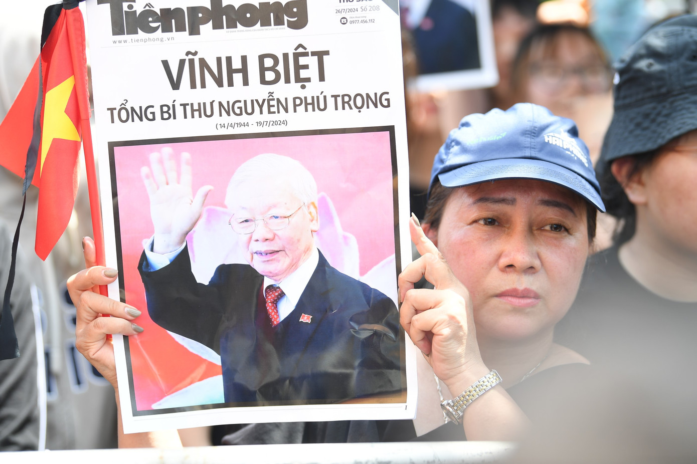 Người dân trân trọng nâng cao hình ảnh Tổng Bí thư Nguyễn Phú Trọng được in trên báo Tiền Phong số ra ngày 26/7. Ảnh: Dương Triều.