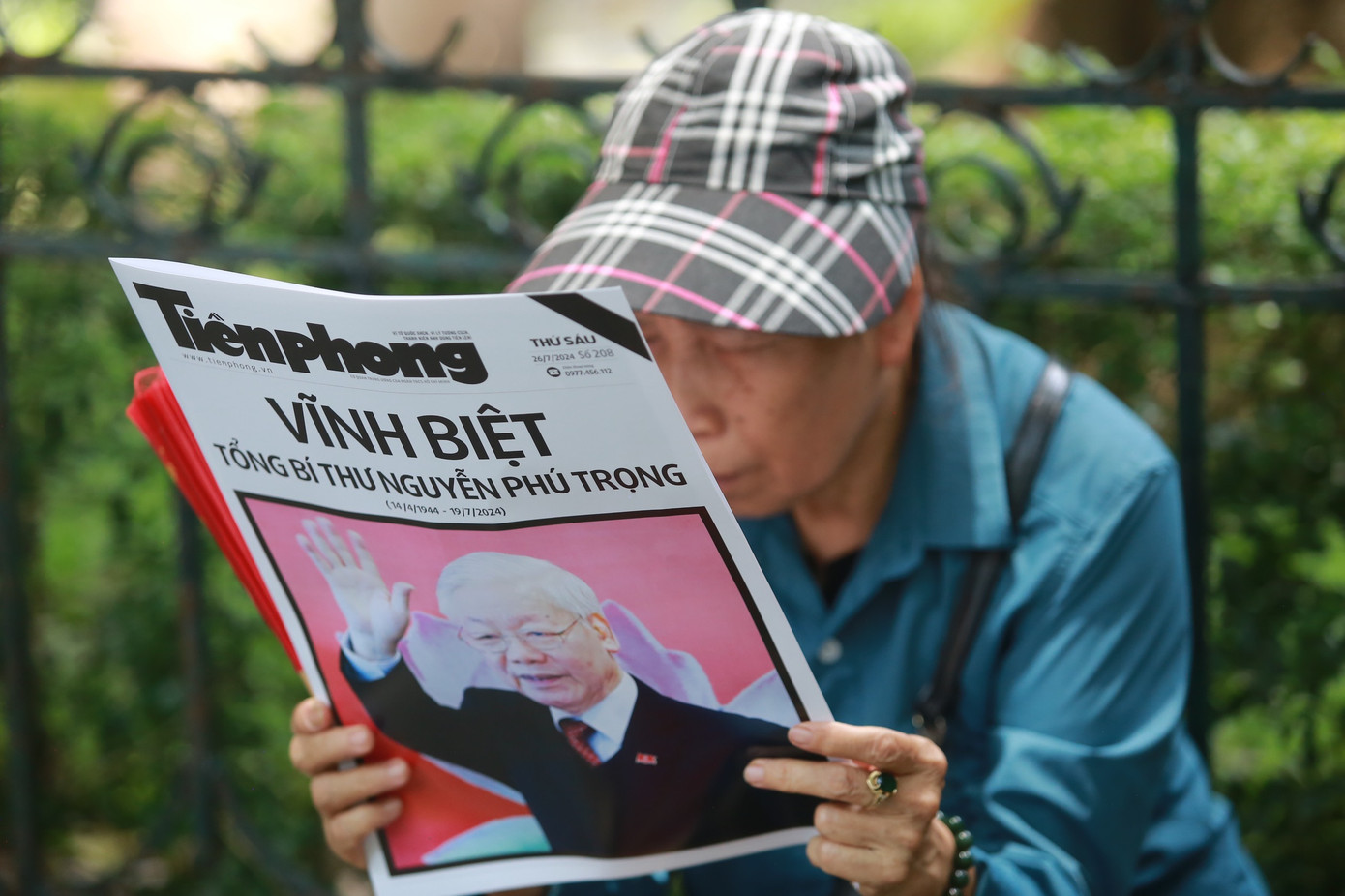 Nhiều người chăm chú đọc thông tin về Tổng Bí thư Nguyễn Phú Trọng trên báo Tiền Phong. Ảnh: Duy Phạm.