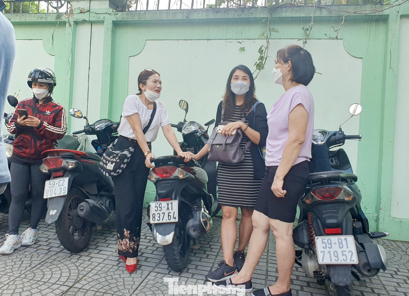 Chị Huệ (thứ 2 từ phải qua) cùng các phụ huynh khác đứng ngoài điểm thi chờ con Chị Huệ (thứ 2 từ phải qua) cùng các phụ huynh khác đứng ngoài điểm thi chờ con