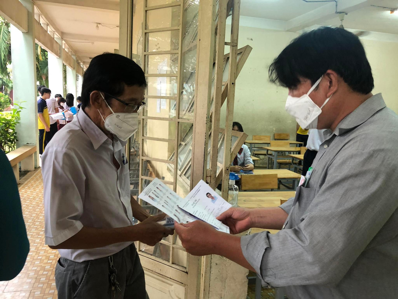 Cán bộ coi thi kiểm tra thông tin ông Đức trước khi vào phòng thi (ảnh: L.P)